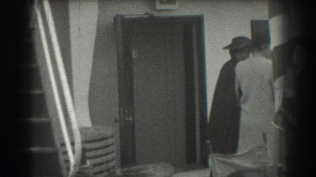 Passengers near a ship doorway and gangway rail, with dark frame edges from the film scan.