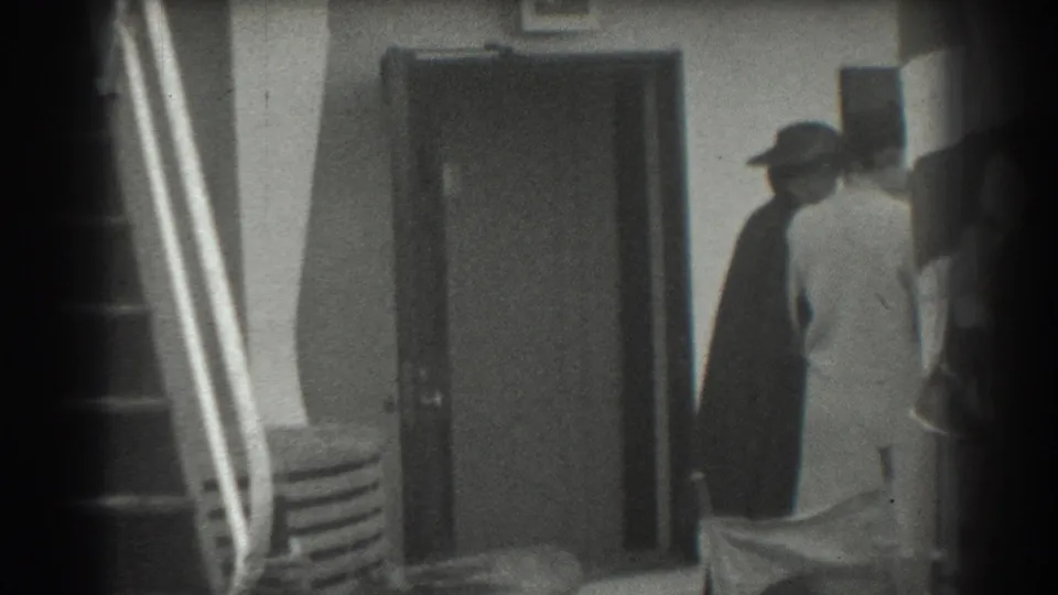 1939 San Francisco home-movie frame showing passengers in coats and hats near a ship entrance and gangway rail.