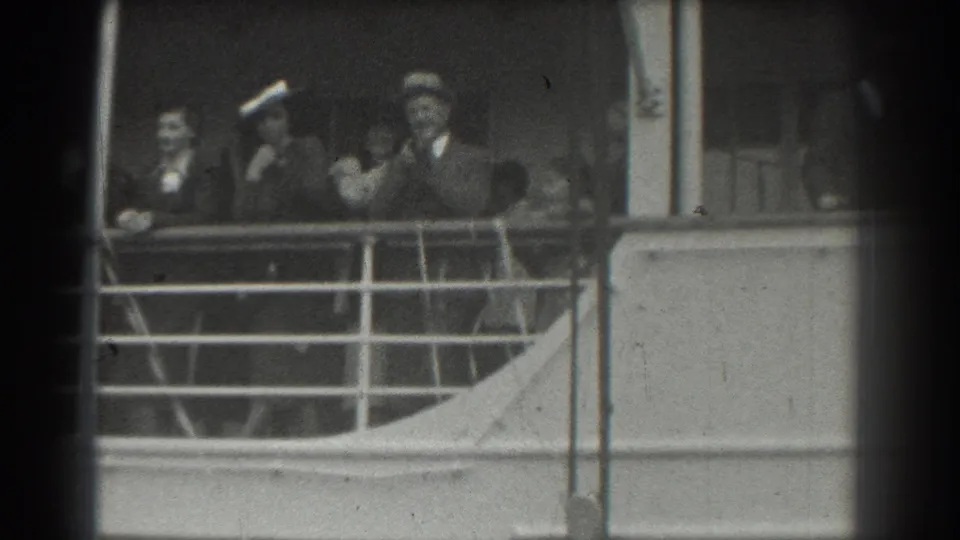 1939 San Francisco frame showing passengers on a cruise ship deck, one appearing to wave toward the camera or shore.