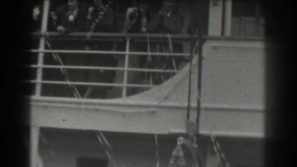 Several passengers cluster near a metal railing on a cruise ship deck in supported 1939 San Francisco home-movie footage.