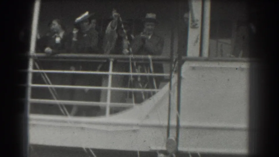 In this 1939 San Francisco home-movie frame, formally dressed passengers stand behind a ship railing and greet the camera.