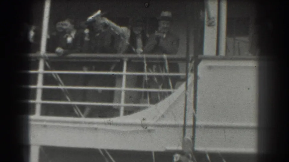 A 1939 San Francisco ship deck scene shows passengers in period dress behind railings, one appearing to raise a hat or hand.