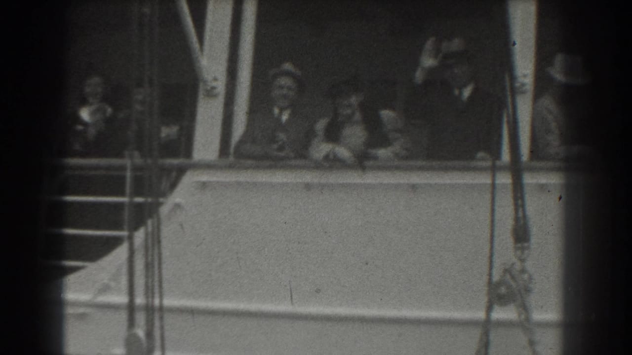 In 1939 San Francisco home-movie footage, passengers in hats and dress clothing stand on a ship deck and wave from behind the railing.