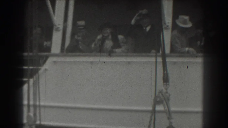 1939 San Francisco home-movie frame showing passengers on a ship deck, including men in hats and a woman near the rail.