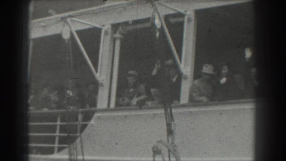 The 8mm frame shows San Francisco ship passengers near the railing, some facing the camera in a farewell moment.