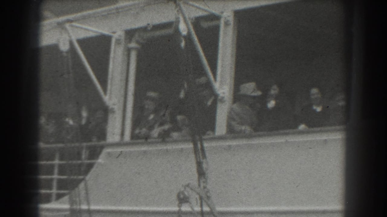 Passengers behind ship windows look outward beside railings and structural supports.