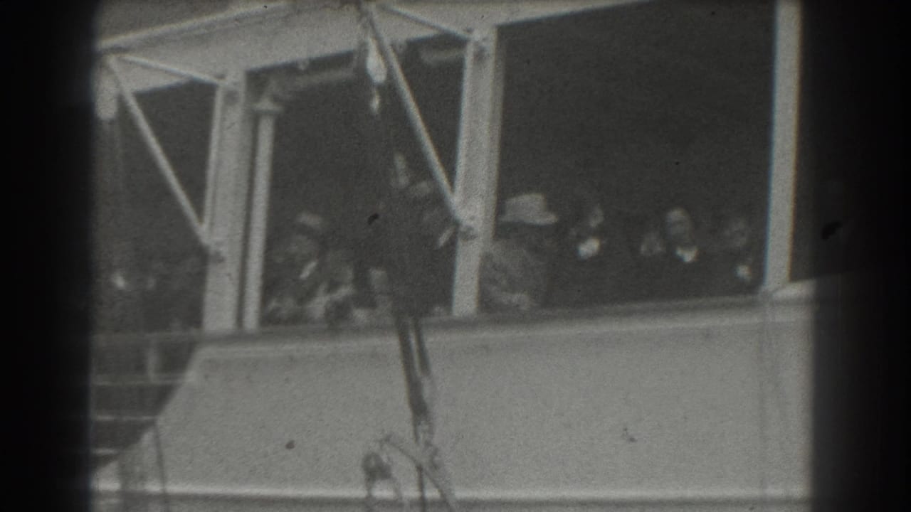 A group of passengers remains visible through large ship windows, with railings below.