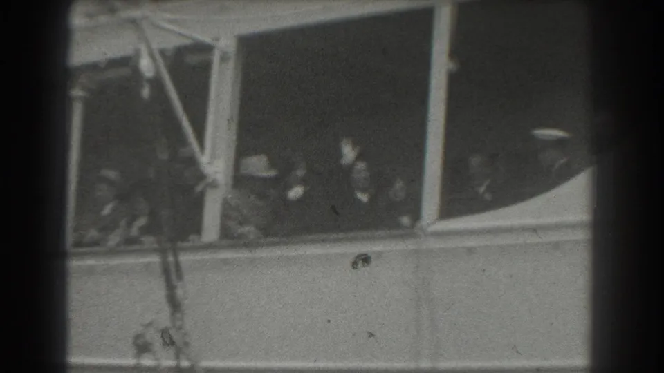 Late-1930s ship departure frame with visible passengers, window frames, railings, and dark 8mm gate edges.