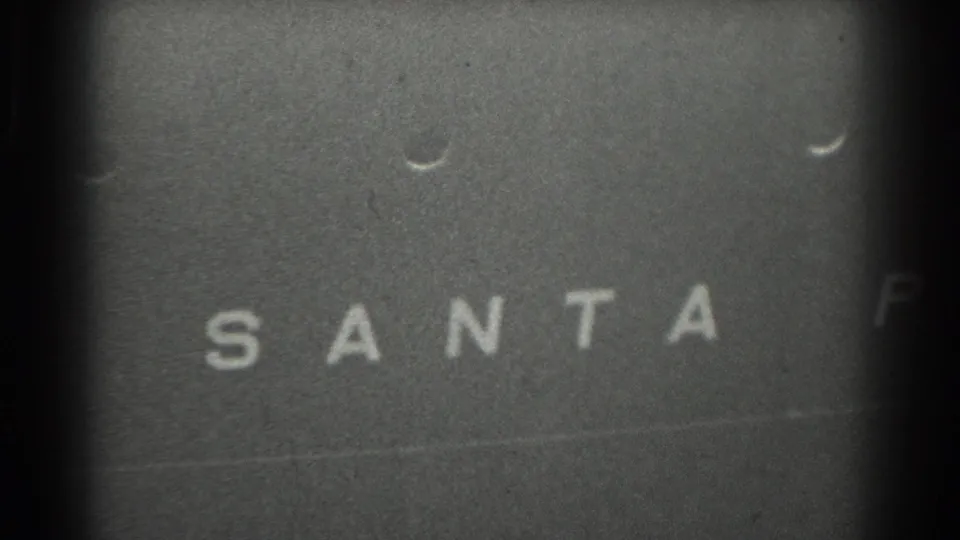 Close view of the ship side with SANTA clearly painted across the surface, recorded in grainy black-and-white 8mm footage.