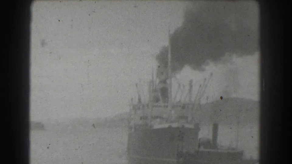 1939 San Francisco 8mm view of a distant steamship on the water, with smoke rising against a cloudy sky.