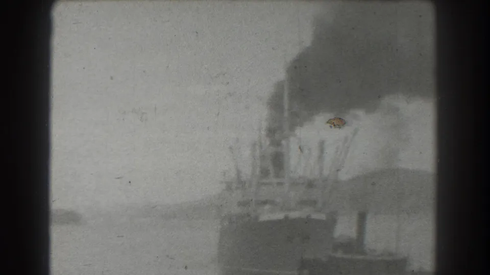 Distant 1939 San Francisco waterfront view with a smoking steamship, open water, and soft hills in the background.