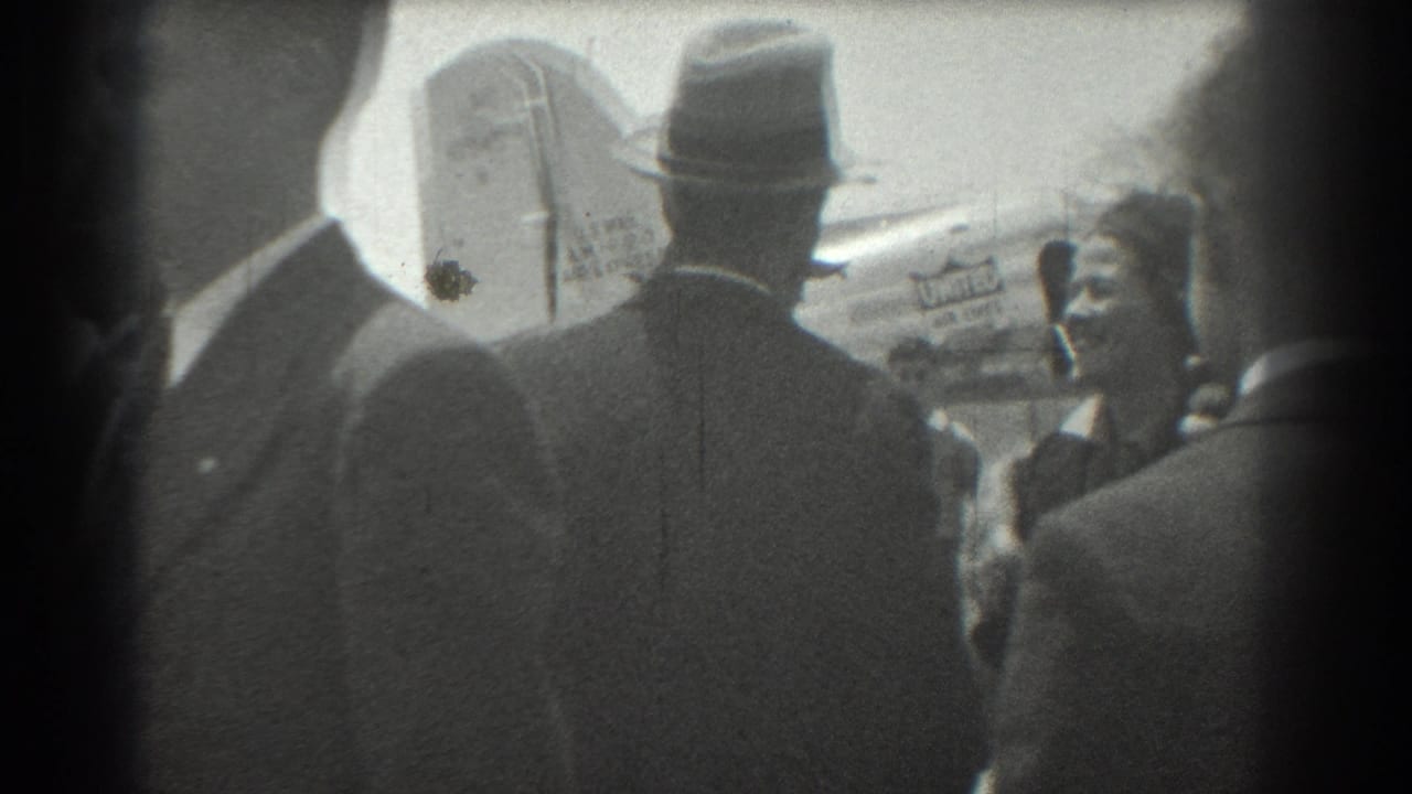 Crowd seen from behind near a United Airlines aircraft tail at an airport.