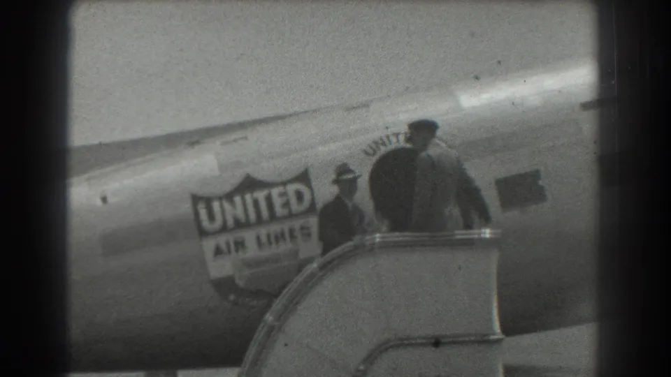 1939 San Francisco frame with two figures near boarding stairs and the United Air Lines logo on the aircraft.