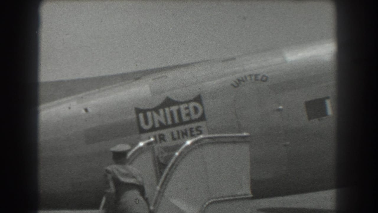 United Air Lines aircraft fuselage beside passenger stairs on a tarmac.