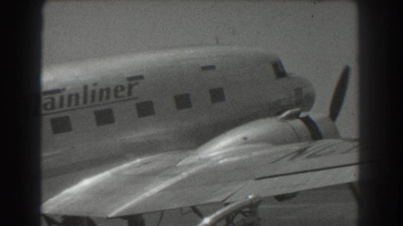 Close view of a propeller airliner fuselage and wing with partial Mainliner lettering.