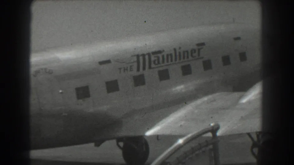 The United Mainliner fuselage fills the frame, with small passenger windows, tarmac equipment, and film gate borders visible.