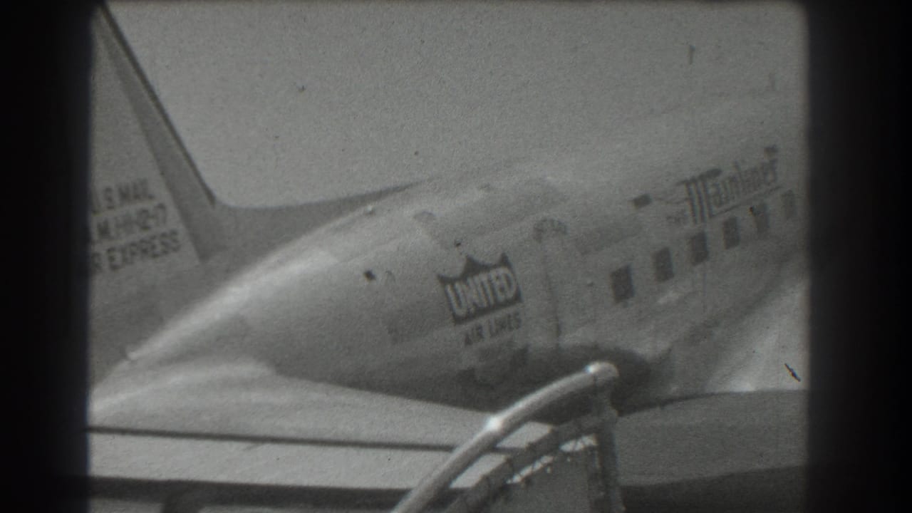 1939 San Francisco home-movie frame showing the rear of a United Air Lines DC-3 with tail and fuselage markings.