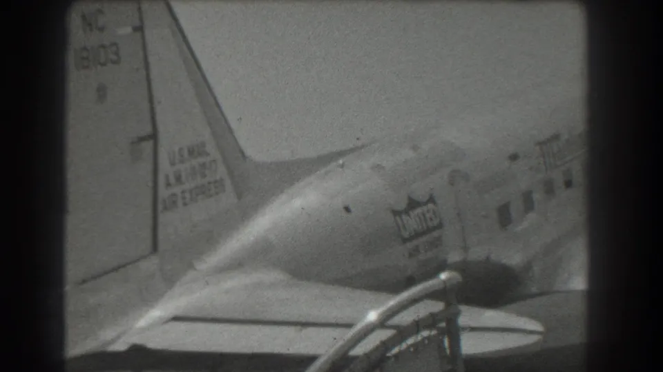 United Air Lines DC-3 rear fuselage and tail appear in a black-and-white 1939 San Francisco airport frame.