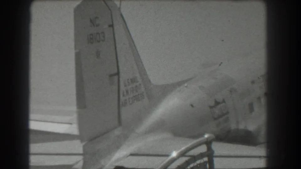 Black-and-white 8mm view of a United Air Lines DC-3 tail and rear fuselage on a San Francisco airport ramp in 1939.