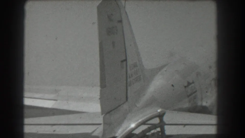 Late-1930s home-movie frame showing a United Air Lines DC-3 rear section with tail, wing, and partial logo.