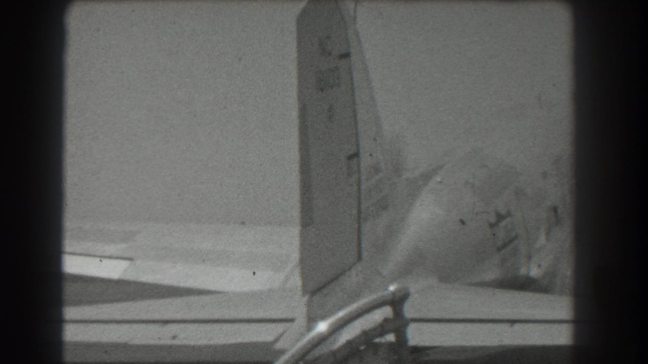 Close view of a twin-engine propeller aircraft tail and wing on a runway.