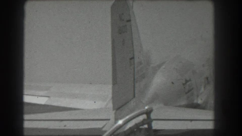 1939 San Francisco 8mm frame showing a propeller aircraft tail, wing surface, and runway-side hardware in black and white.