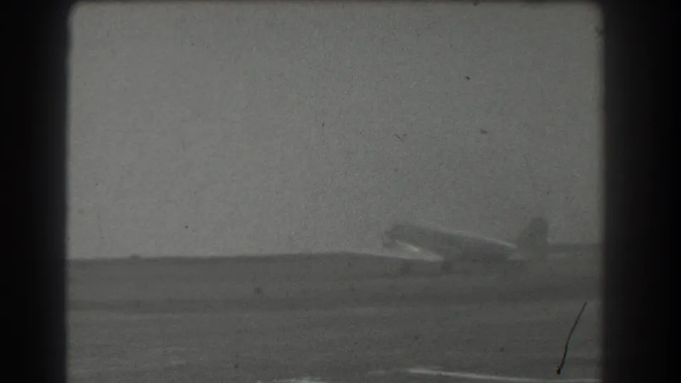 Soft black-and-white 8mm view of a light-colored airplane on an open runway, consistent with the 1939 San Francisco metadata.