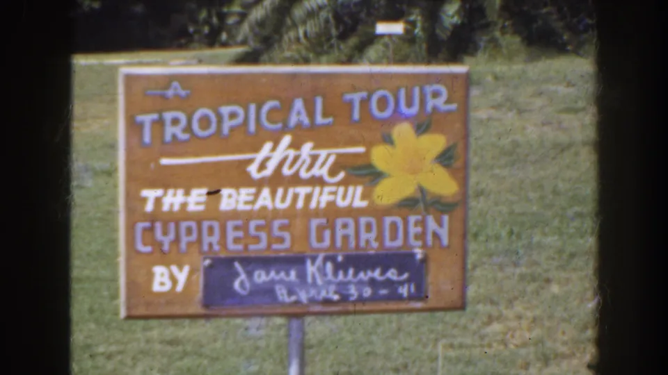 Another 1941 Florida frame of the hand-painted Cypress Garden tour sign, with soft color and visible film wear.
