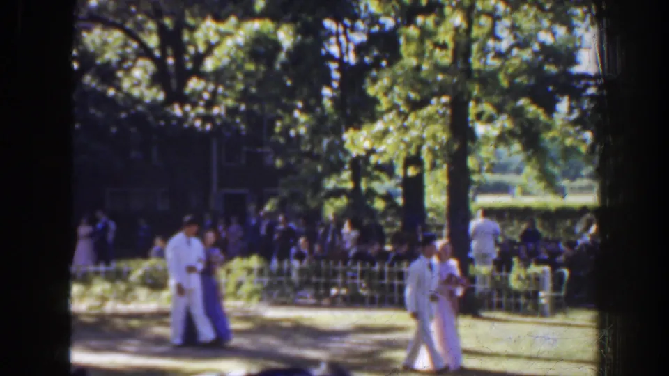 Two formally dressed couples are visible on the lawn during the Florida ceremony, with guests and trees forming a shaded background.