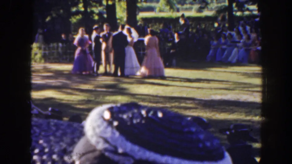 Bride, groom, and young attendants pause together in a 1941 Florida park wedding scene, filmed from a family home-movie viewpoint.