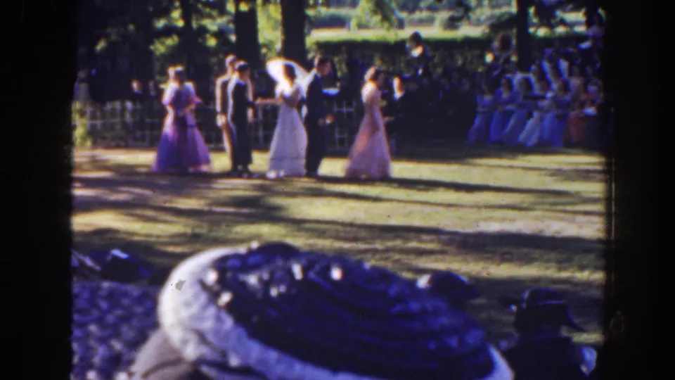 The bride, groom, and attendants stand on a shaded Florida lawn in 1941, with seated guests watching from behind a low fence.