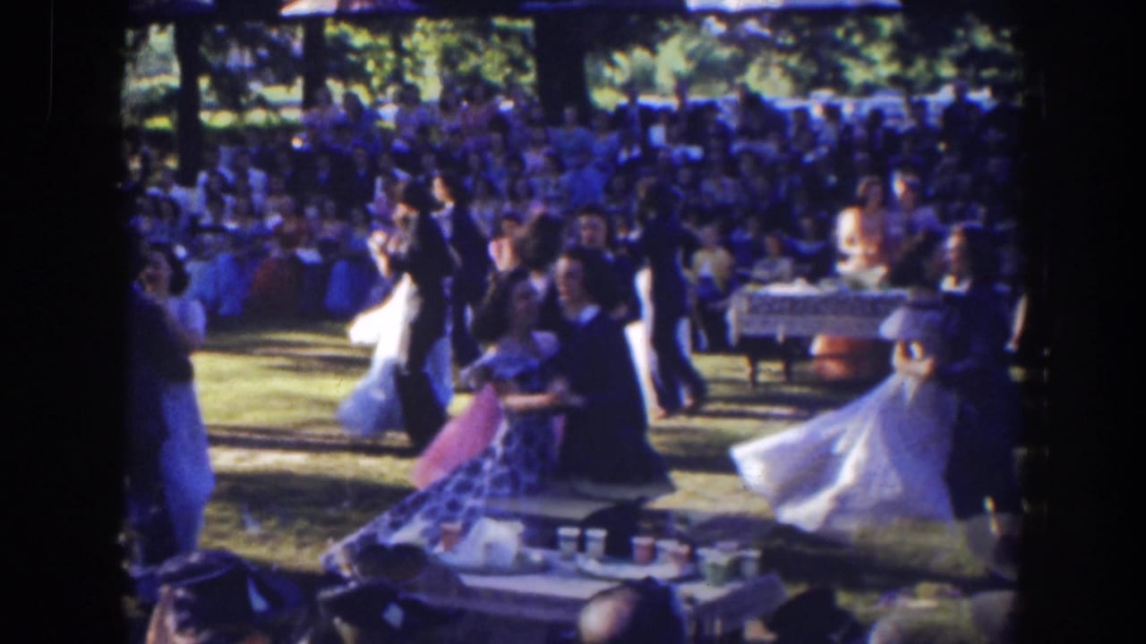 In 1941 Florida home-movie footage, formally dressed couples dance outdoors on a lawn while spectators sit behind them.