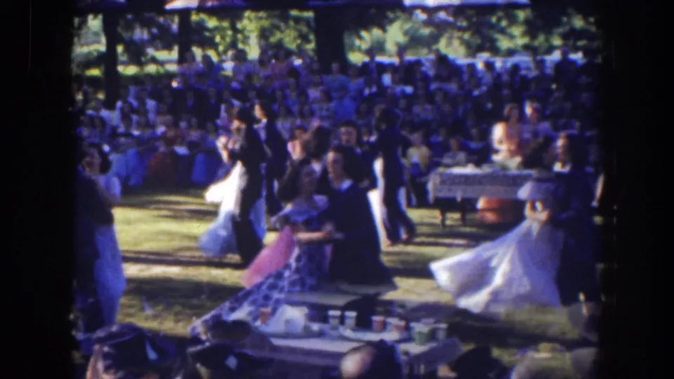 In 1941 Florida home-movie footage, formally dressed couples dance outdoors on a lawn while spectators sit behind them.