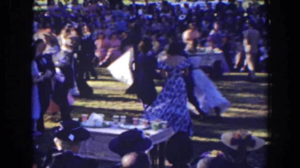 A 1941 Florida outdoor dance scene shows couples in formal wear moving across the grass near a refreshment table and audience.