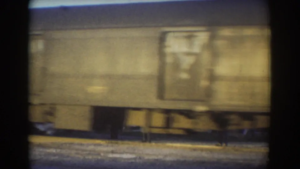 A beige freight car with a visible rectangular side panel passes the camera in York, Nebraska, 1958.