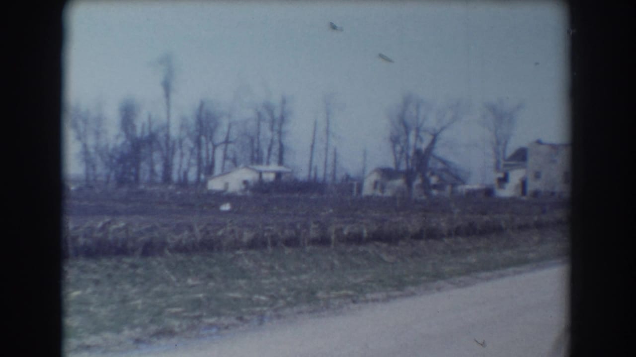 York, Nebraska home-movie frame from 1958 with a small distant house, open field, bare trees, and soft 8mm color.