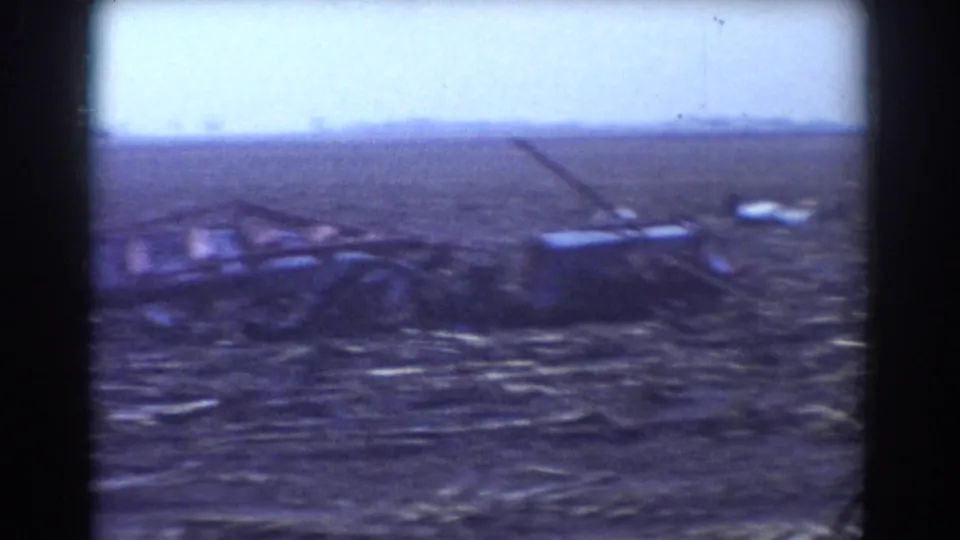1958 storm aftermath frame showing collapsed debris or equipment remnants in a rural York, Nebraska field.