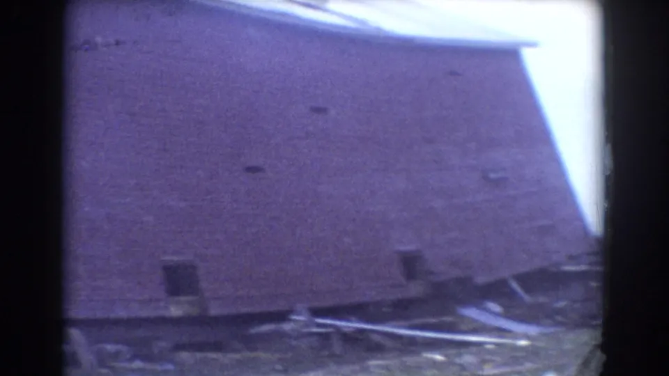 Close 8mm view of storm damage in York, Nebraska, showing a collapsed roofline or wall section with scattered boards and debris.