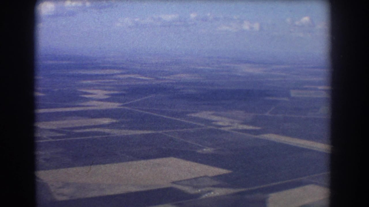 Aerial view of patchwork farmland seen through a film frame.