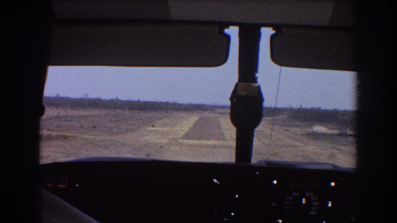 Cockpit view facing a runway through an aircraft windscreen.