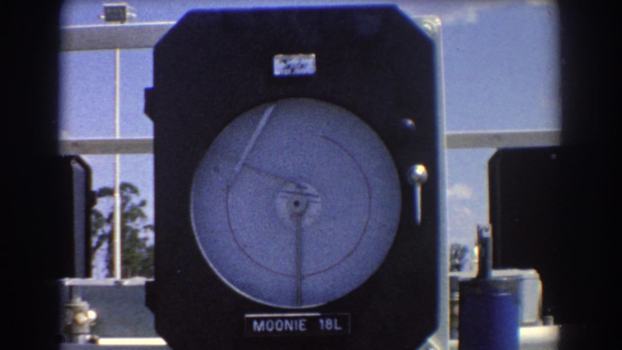 Close view of a Moonie 18L industrial gauge in a dark housing.