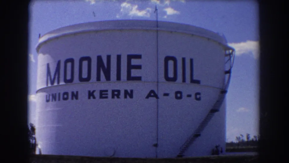 1967 Brisbane 8mm frame showing a large white Moonie Oil tank with Union Kern A-O-C lettering and a ladder at the side.