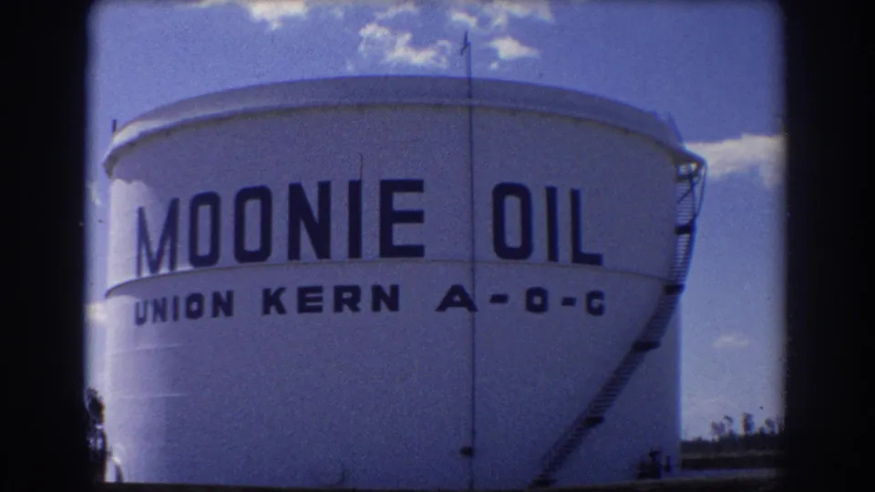 1967 Brisbane 8mm frame of the Moonie Oil storage tank, with Union Kern A-O-C text visible below the main lettering.
