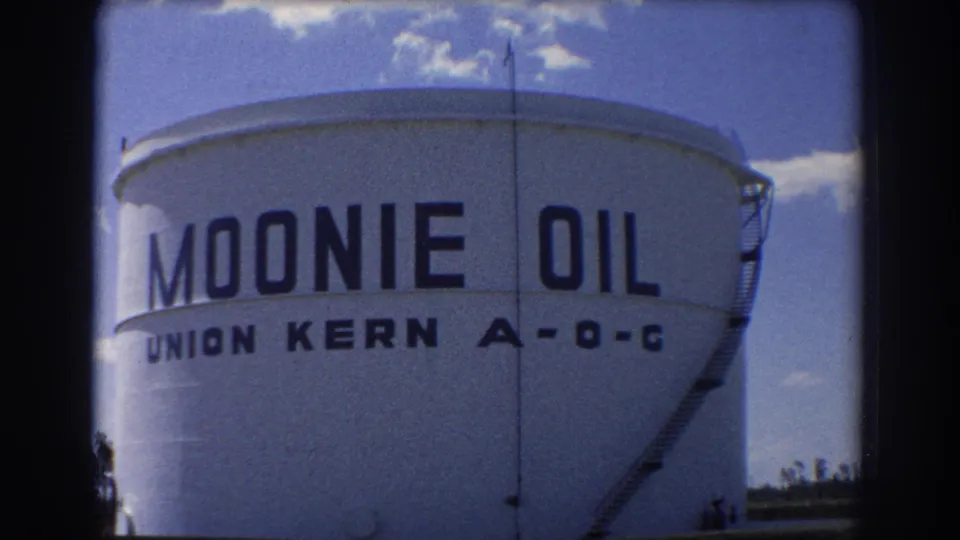 1967 Brisbane 8mm frame showing the painted Moonie Oil and Union Kern A-O-C markings across a large white storage tank.