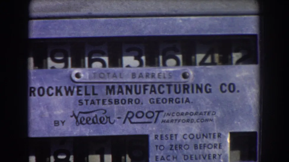 1967 Brisbane 8mm frame showing a tight view of a Rockwell TOTAL BARRELS counter with high numerals and Feeder-Root distribution text.