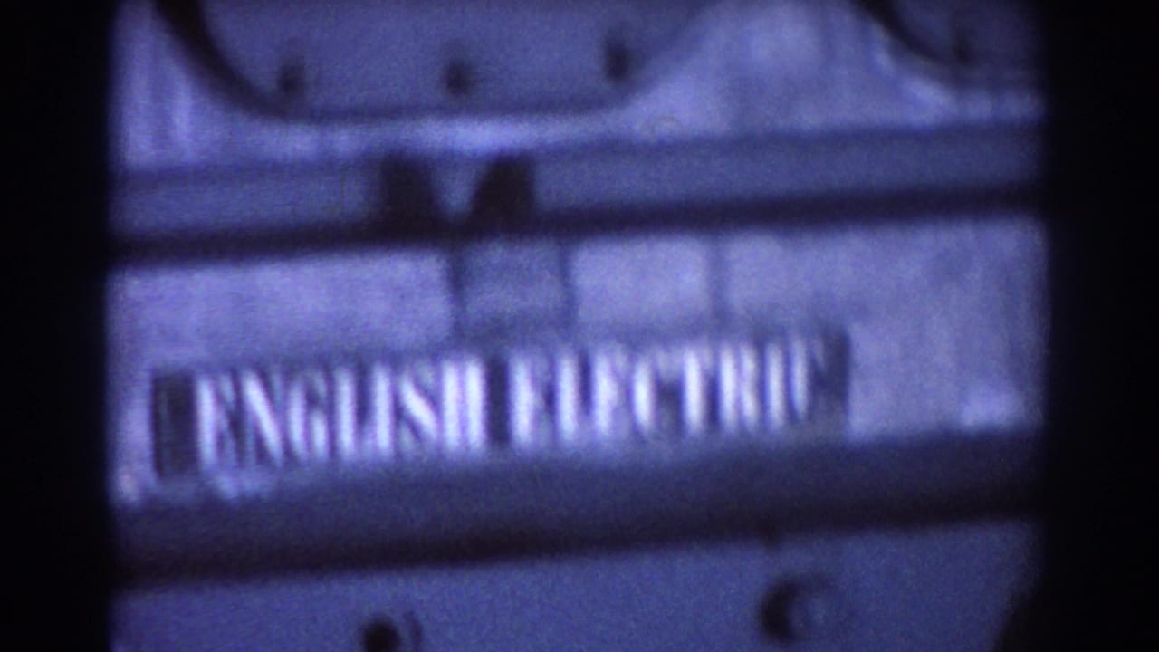 Soft close-up of machinery with a blurred English Electric label on a dark metal casing.