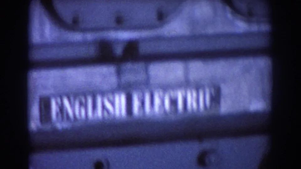 Close 1967 Brisbane 8mm view of a dark industrial machine casing with a partially blurred English Electric label.