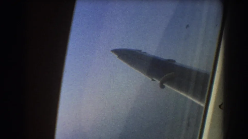 Passenger-window view of an aircraft wing against hazy blue sky, matching the 1967 Brisbane, Australia travel metadata.