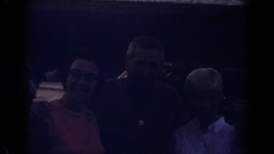 Underexposed home-movie view of a family group standing together in Fort Lauderdale, Florida, in 1967.