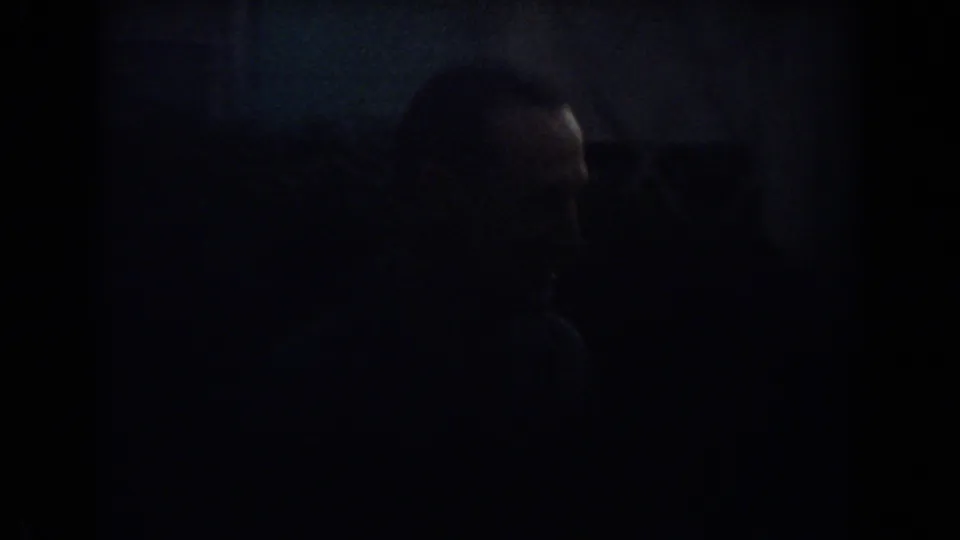 In 1967 Fort Lauderdale home-movie footage, a man appears in low light near a parked car or garage area.